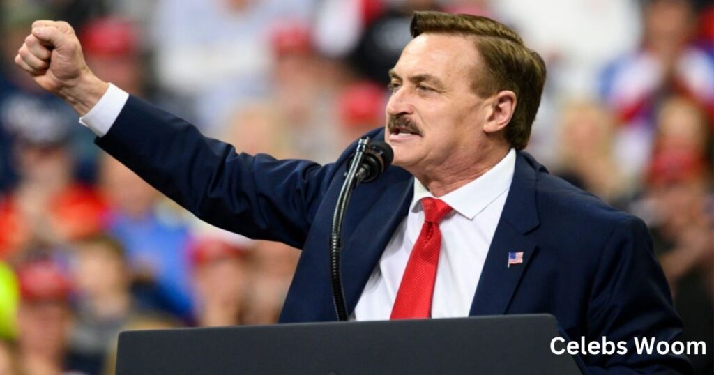 Person in a suit with raised fist, standing at a podium.