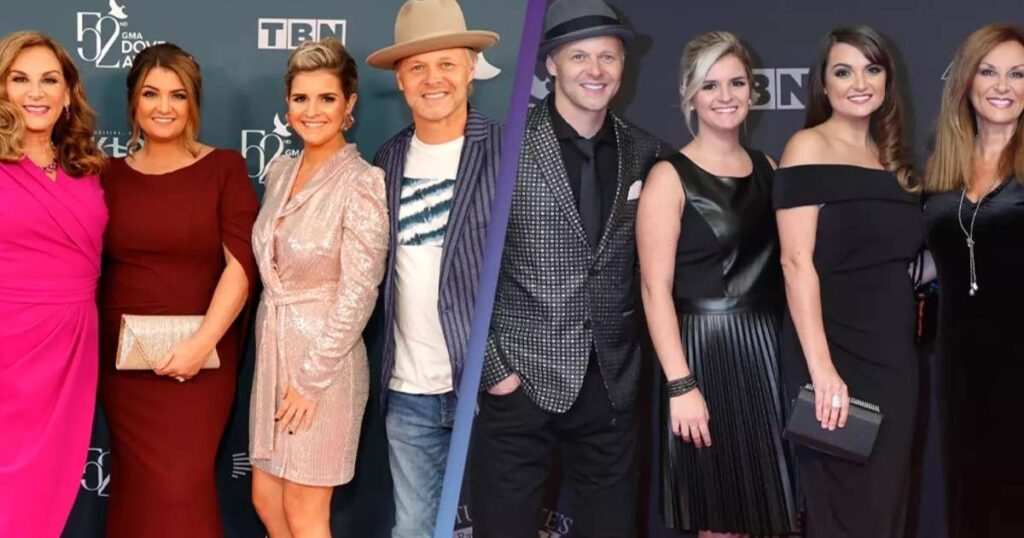 Group of people in formal attire at an event, with a "50th GMA Dove Awards" backdrop.